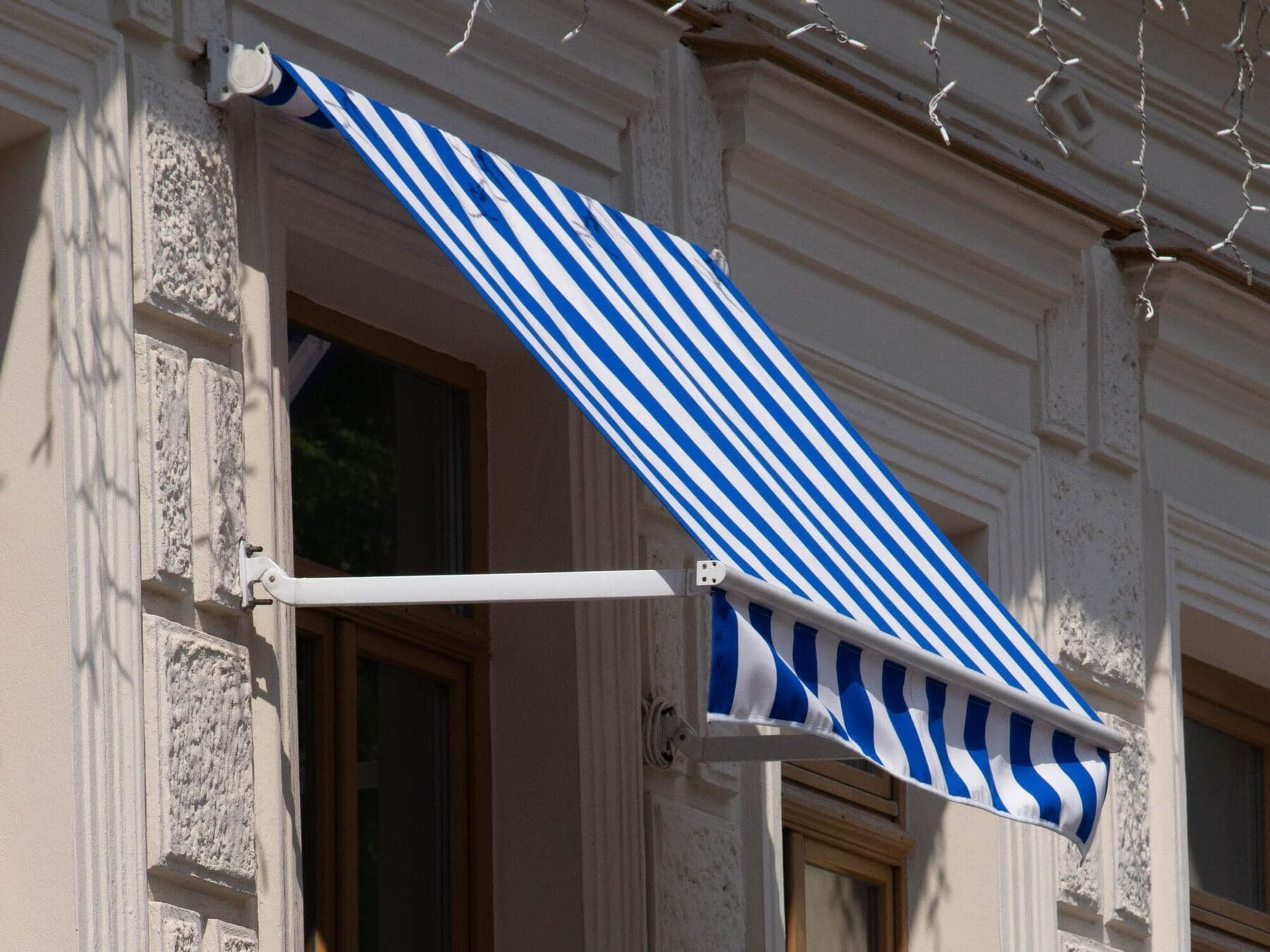 Ausgefahrene Gelenkarmmarkise an einem Altbaubalkon