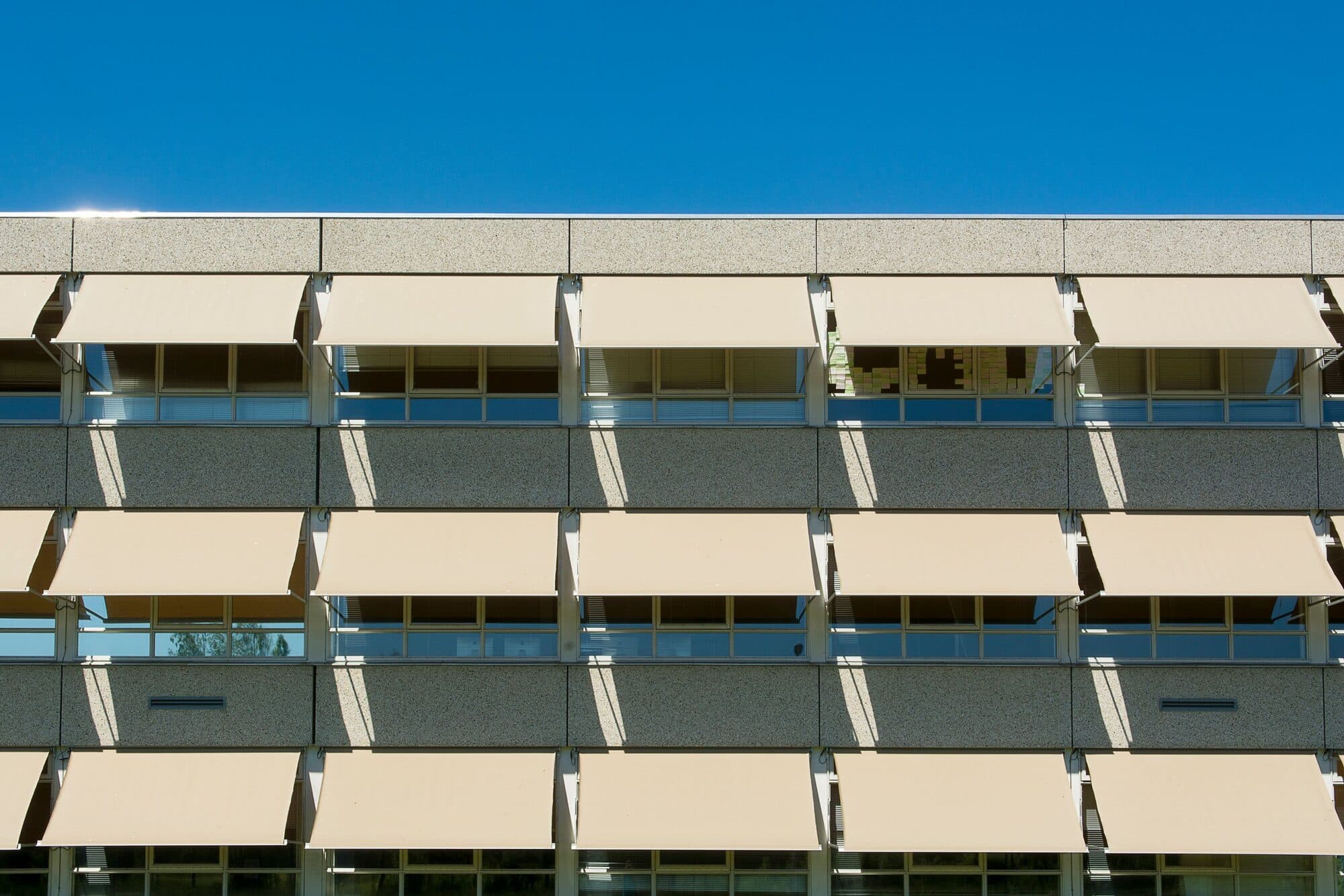 Hausfassade mit Markisen und außenliegendem Sonnenschutz